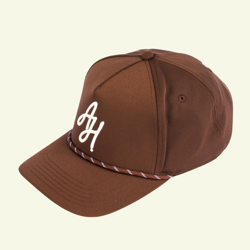 Load image 1 in gallery view. Close-up of white AH embroidery and brown and white braided rope on a brown golf cap